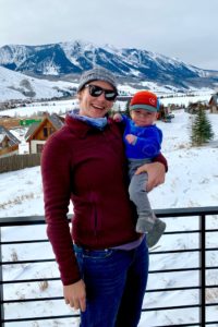 Katie Hicks, DPT at Carolina Physical Therapy, with her child with a snow covered mountain behind them. 