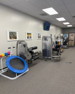 Treatment room at Carolina PT Johns Island with equipment for shoulder and knee rehabilitation, hand therapy, and spine care.