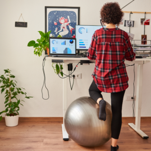 photo of a woman with an ergonomically suitable work station at home, promoting physical therapy expertise to live a pain free life. 
