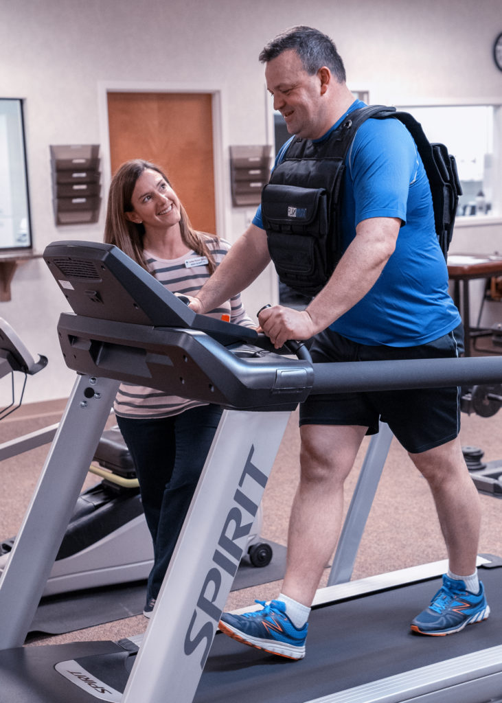 Patient came to Carolina Physical Therapy for foot pain relief. In this photo, the patient is receiving plantar fasciitis treatment on a treadmill with PT, while learning about arch support and custom orthotics.